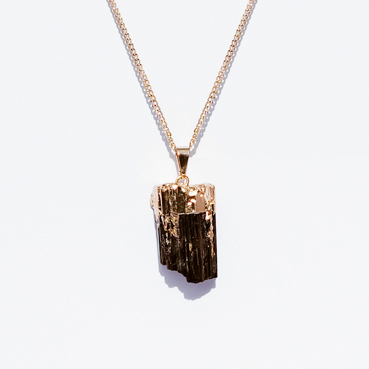 Black tourmaline pendant necklace on neutral background 